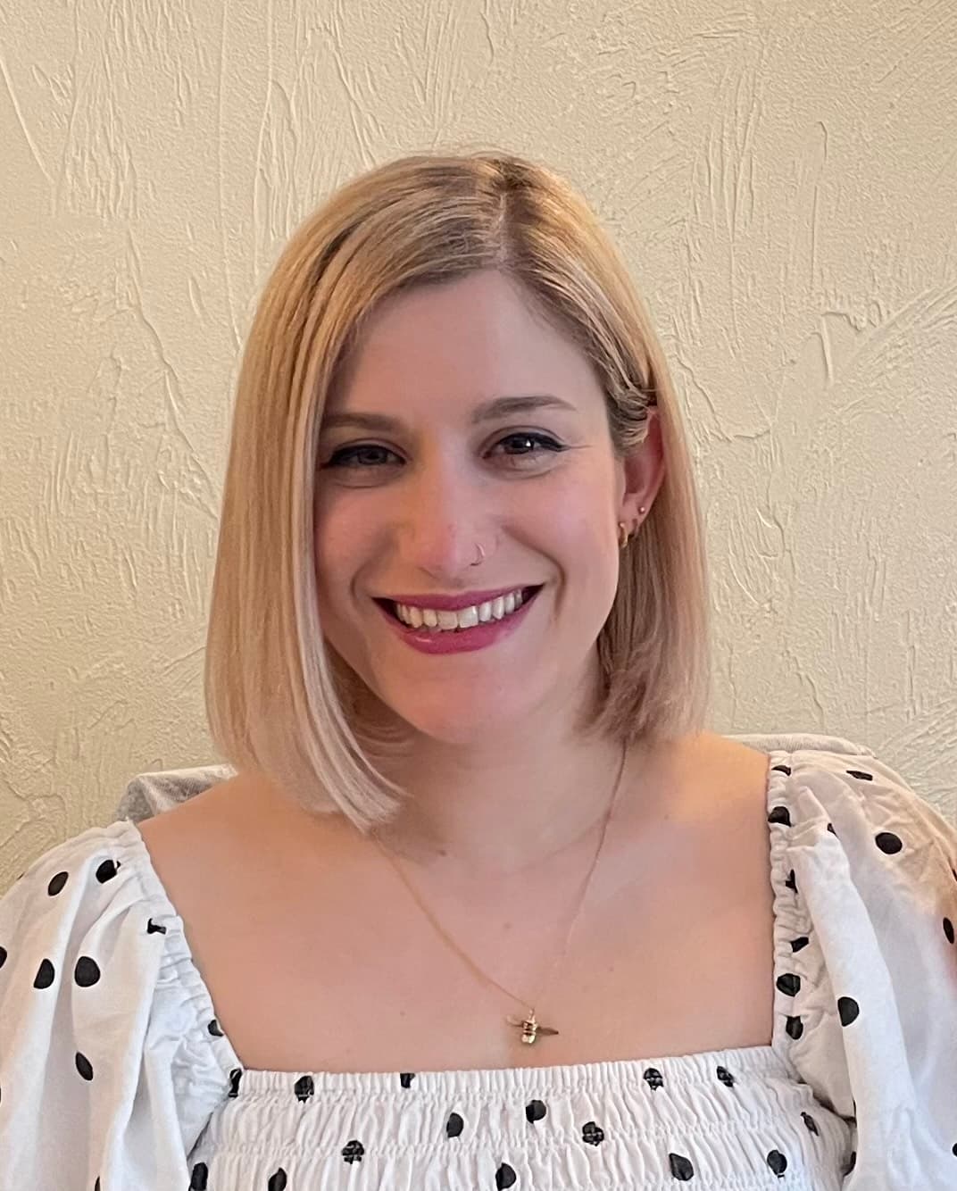 A headshot of Gem smiling on a neutral background.