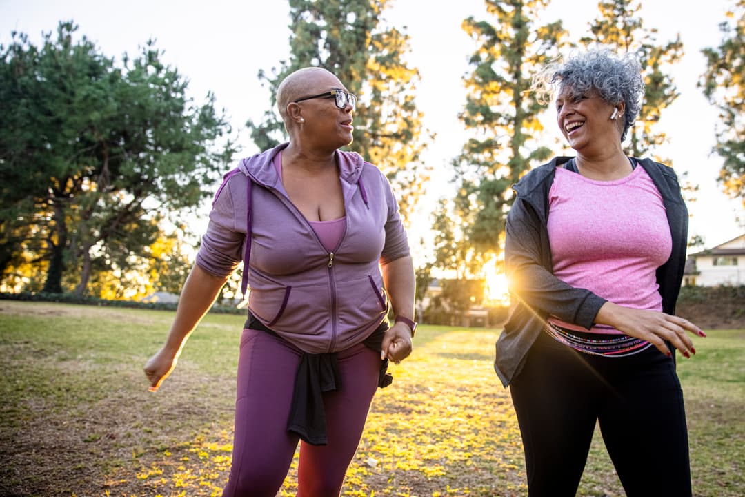 Two women walking in a park.